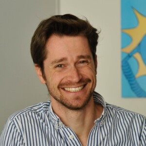 Portrait de Quentin Mourcou, homme cheveux courts souriant, chemise rayée